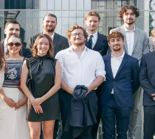 Groupe d'étudiants du Programme Grande École HETIC posant sur une terrasse à Londres avec la tour The Gherkin en arrière-plan
