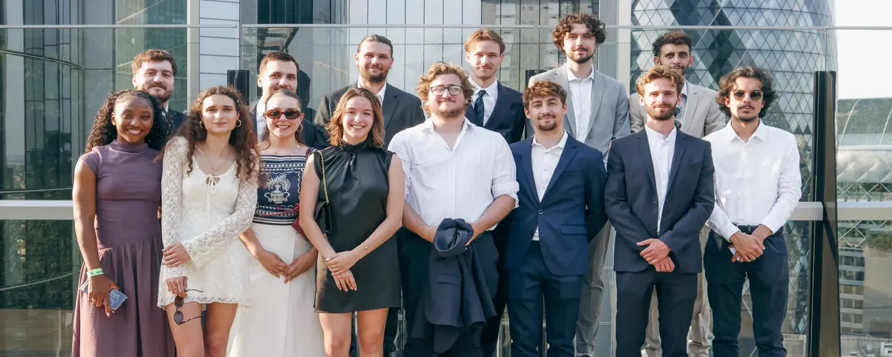 Groupe d'étudiants du Programme Grande École HETIC posant sur une terrasse à Londres avec la tour The Gherkin en arrière-plan
